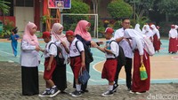 Tak hanya dengan orang tua, para siswa juga terlihat bersalaman dengan guru-guru yang telah berjajar menyambut kedatangan mereka.