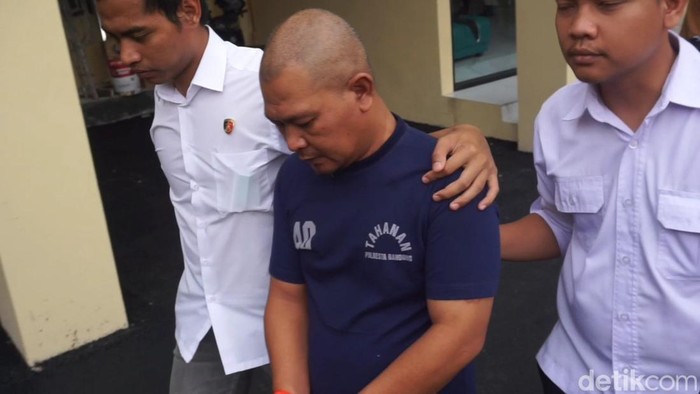 Kepala cleaning service, Rendi alias Sambo (43) tertunduk lesu saat dihadirkan di Mapolresta Bandung