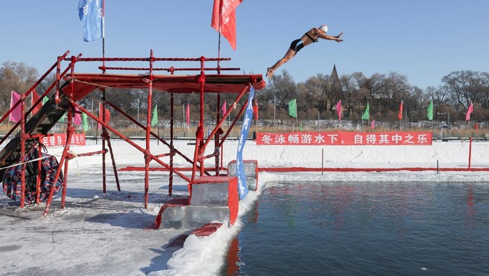 A winter swimming event participant swims in cold water during the annual ice and snow sculpture festival, in Harbin, Heilongjiang Province, China, January 5, 2026.  REUTERS/Go Nakamura