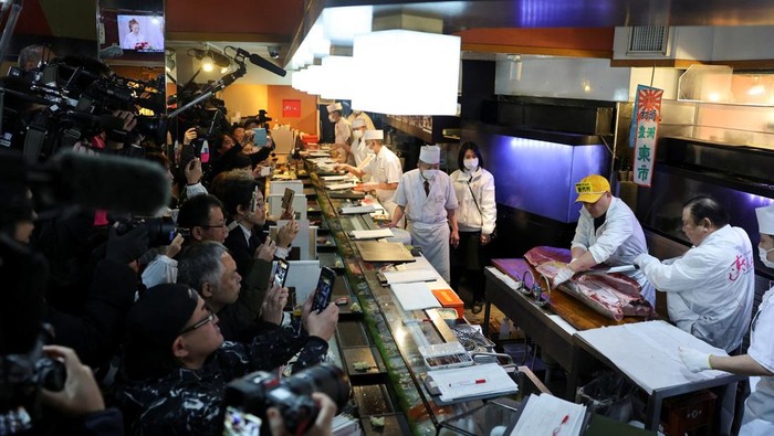 Tuna Sirip Biru Cetak Rekor Harga di Lelang Awal Tahun Tokyo A staff member of Kiyomura Co, which runs a chain of sushi restaurants, Sushi Zanmai, poses with the head of a 243-kilogram bluefin tuna auctioned for a record 510 million yen ($3.24 million) at the first auction of 2026 at Tokyo's Toyosu fish market, after cutting the tuna at the sushi restaurant in Tokyo, Japan, January 5, 2026. REUTERS/Kim Kyung-Hoon