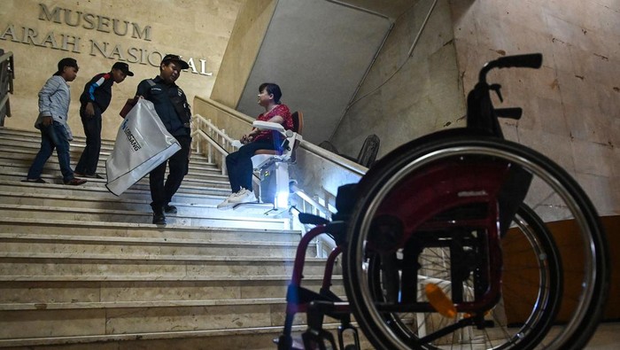 Petugas mendampingi warga penyandang disabilitas menaiki lift chair atau kursi angkat di Monas, Jakarta, Selasa (6/1/2026). Unit Pengelola Kawasan Monumen Nasional menyediakan fasilitas lift chair yang diperuntukkan bagi penyandang disabilitas, lansia, serta pengunjung yang membutuhkan bantuan akses menaiki tangga demi mendukung ruang publik yang inklusif. ANTARA FOTO/Sulthony Hasanuddin/bar