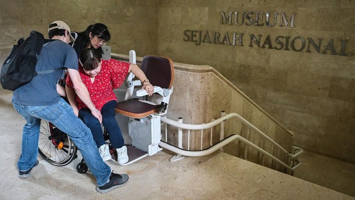 Petugas mendampingi warga penyandang disabilitas menaiki lift chair atau kursi angkat di Monas, Jakarta, Selasa (6/1/2026). Unit Pengelola Kawasan Monumen Nasional menyediakan fasilitas lift chair yang diperuntukkan bagi penyandang disabilitas, lansia, serta pengunjung yang membutuhkan bantuan akses menaiki tangga demi mendukung ruang publik yang inklusif. ANTARA FOTO/Sulthony Hasanuddin/bar