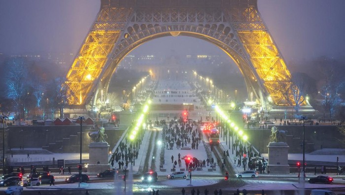 People walk in the snow-covered Trocadero Gardens near the Eiffel Tower, as winter weather with snow and cold temperatures hits a large part of the country, in Paris, France, January 5, 2026. REUTERS/Gonzalo Fuentes