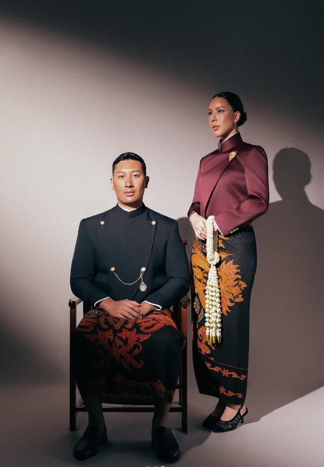 Sesi prewedding DJ Patricia Schuldtz dan Darma Mangkuluhur mengusung konsep adat Jawa modern. Darma Mangkuluhur tampil gagah mengenakan beskap hitam beraksen kancing emas, dipadukan dengan kain batik bernuansa cokelat kemerahan bermotif klasik. Sementara Patricia mengenakan kebaya janggan berwarna burgundy dengan potongan tegas dan modern, dipadukan dengan kain batik bernuansa gelap bermotif besar. Foto: Instagram/@pschuldtz