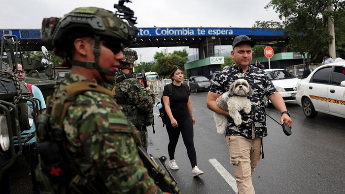 A soldier stands guard as people on their motorbikes cross the border between Venezuela and Colombia, after the U.S. struck Venezuela and captured its President Nicolas Maduro, in Cucuta, Colombia, January 5, 2026. REUTERS/Luisa Gonzalez