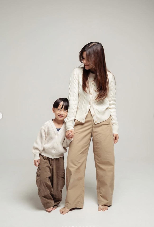 Kompak dengan sang anak, Audi juga mengenakan cardigan berwarna coklat muda. Tampil santai, ia memadukannya dengan celana panjang berpotongan longgar dengan warna senada. Foto: Instagram/@audimarissa