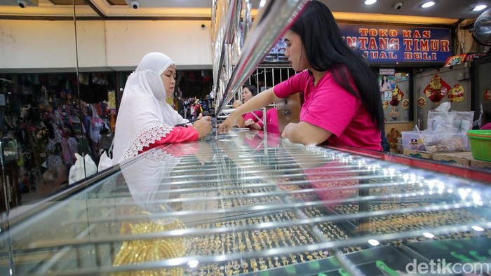 Petugas toko menampilkan emas batangan kepada pembeli di sebuah gerai penjualan emas di Kebayoran, Jakarta, Rabu (7/1/2026). Sejak awal 2026, permintaan emas di gerai setempat meningkat dengan rata-rata puluhan transaksi per hari, didominasi pembelian pecahan 5 dan 10 gram.