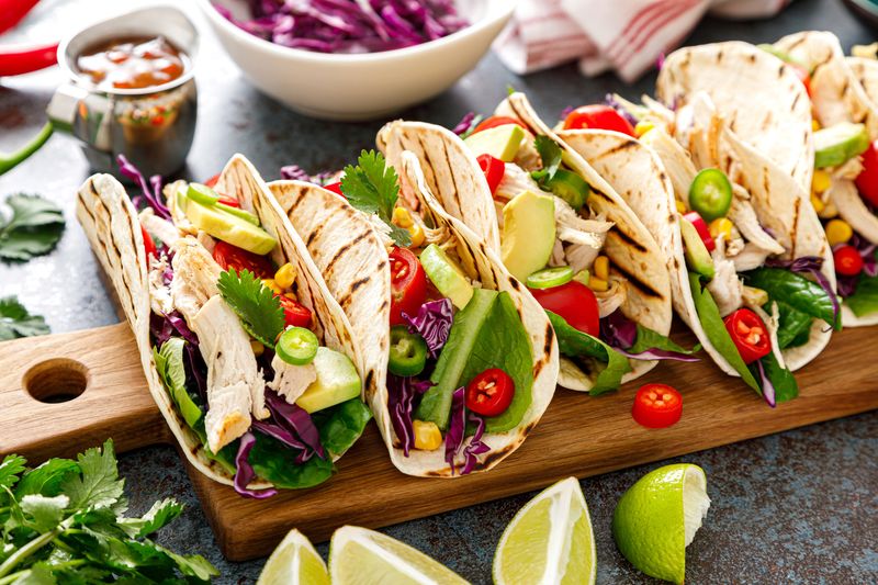 Chicken tacos with grilled meat, avocado, fresh vegetable salad and sauce salsa