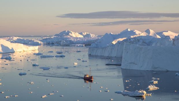 Kapal nelayan di antara gunung es di Ilulissat Icefjord.