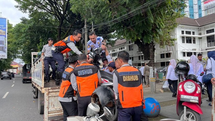 Petugas Dishub Makassar mengangkut motor pegawai di Balai Kota Makassar karena parkir sembarangan.