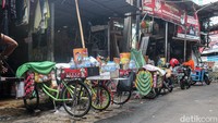 Di sudut kampung, tampak ibu-ibu turut membantu merapikan gerobak dan menyiapkan kebutuhan berjualan. Dari lorong-lorong sempit di Kwitang, para pedagang kopi keliling ini mengayuh sepeda setiap hari, membawa harapan dan secangkir kopi hangat bagi warga Jakarta.