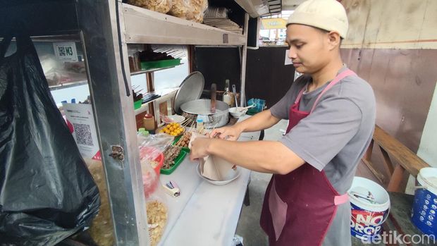 Salah seorang pedagang bubur ayam di Tasikmalaya membungkus dengan kertas nasi Salah seorang pedagang bubur ayam di Tasikmalaya membungkus dengan kertas nasi