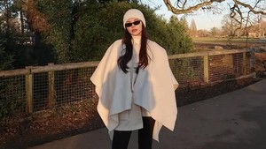 Cape putih, celana hitam, dan boots tinggi jadi formula aman Alyssa buat tampil chic di udara dingin. Foto: Instagram Alyssa Daguise