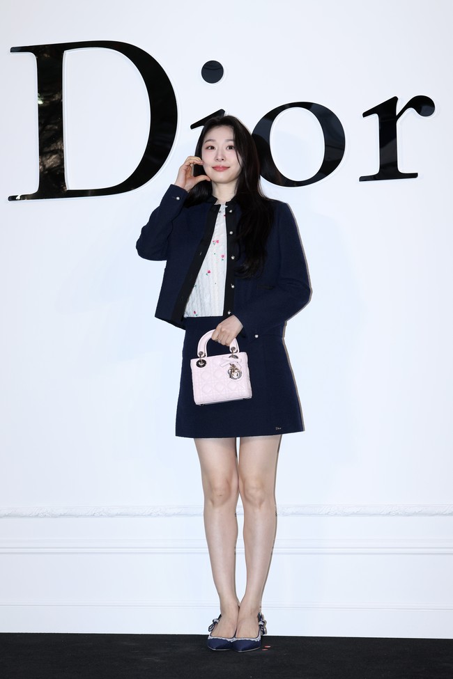 Mantan figure skater Korea Selatan, Yuna Kim menarik perhatian sebagai perwakilan DIOR. Kali ini, ia bergaya semi kasual memakai jaket dan mini skirt berwarna navy, dengan atasan putih bermotif floral. Foto: Getty Images