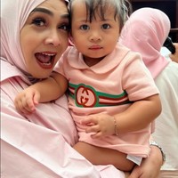 Digendong oleh sang nenek, Lily tampil mengenakan dress berkerah warna pink. Dress tersebut berasal dari merek mewah Gucci yang harganya mencapai Rp 8,3 juta. Foto: Instagram