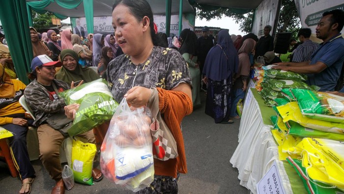 Warga membawa beras medium SPHP dan kebutuhan pokok yang dibeli saat pasar murah di Tanggulangin, Sidoarjo, Jawa Timur, Kamis (8/1/2026). Pemerintah Provinsi Jawa Timur menyiapkan 110 titik pasar murah yang diselenggarakan di seluruh kabupaten dan kota di wilayah setempat pada 2026 dalam upaya untuk menjaga harga bahan kebutuhan pokok, khususnya menjelang Ramadhan 1447 Hijriah. ANTARA FOTO/Umarul Faruq/nz