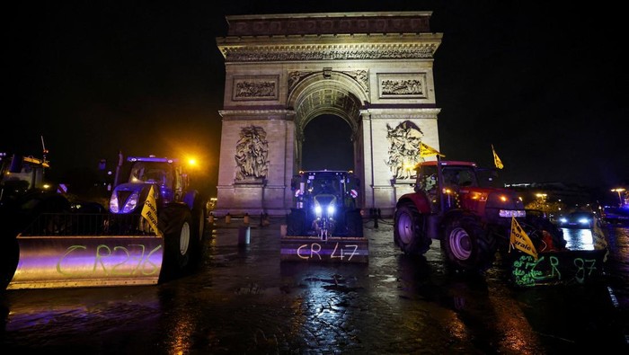 Farmers from the Coordination Rurale union stand next to tractors are parked in front of the Arc de Triomphe during a protest against the government's handling of the EU-Mercosur free trade agreement and the handling of the lumpy skin disease outbreak, in Paris, France January 8, 2026. REUTERS/Sarah Meyssonnier