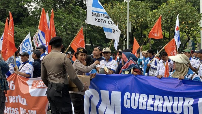 Polisi Bagikan Air Mineral dan Roti ke Massa Buruh di Monas