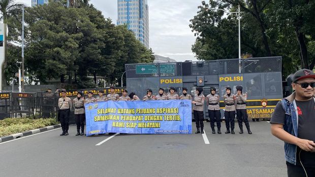 Polisi Bagikan Air Mineral dan Roti ke Massa Buruh di Monas