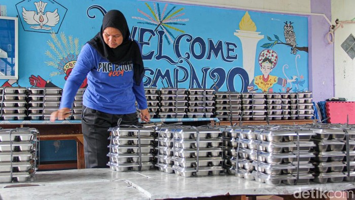 Program Makan Bergizi Gratis kembali berjalan pada 2026. Program ini dijalankan di SMP 20 Jakarta Timur, Kramat Jati, Kamis (8/1/2026). Sejak siang para siswa terlihat antre secara tertib untuk menerima paket makanan bergizi yang disediakan.