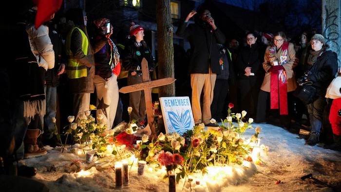 A woman reacts next to a memorial site during a vigil for a 37-year-old woman who was shot in her car by a U.S. immigration agent, according to local and federal officials, in Minneapolis, Minnesota, U.S., January 7, 2026. REUTERS/Tim Evans     TPX IMAGES OF THE DAY
