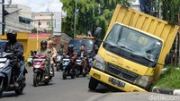  Bagian kiri truk tersebut terperosok ke dalam selokan.   