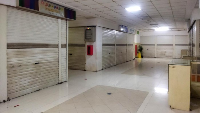 Suasana sepi terlihat di Tamini Square, Jakarta Timur, pada Jumat (9/1/2026), dengan banyak toko tutup dan pintu besi tertutup rapat berjajar di sepanjang lorong.