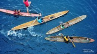 Anak anak koin di perahu menanti penumpang melempar uang, satu anak melompat ke air.