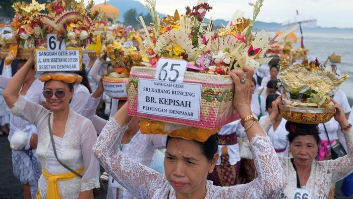 Nelayan membantu umat Hindu yang membawa sesajen menuju ke tengah laut menggunakan perahu saat ritual mesucian di Pantai Saba, Gianyar, Bali, Sabtu (10/1/2026). Kegiatan yang diikuti ratusan umat Hindu se-Bali tersebut merupakan rangkaian upacara Ngusaba Karang Pengulu I di Pura Kawitan Karang Buncing yang digelar setiap 7 tahun sekali. ANTARA FOTO/Nyoman Hendra Wibowo