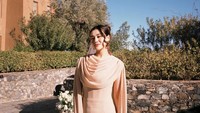 Aaliyah Massaid memakai long dress bernuansa pastel. Bagian atas gaun menggunakan cape modern yang memanjang dengan layer di bagian dada. Aaliyah menyanggul rambutnya. (Foto: Instagram @aaliyah.massaid)