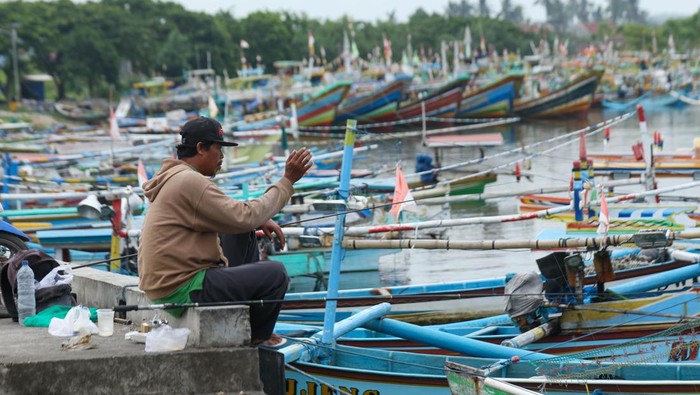 Sejumlah warga memancing di area Dermaga Pelabuhan Tempat Pelelangan Ikan (TPI) Pantai Gerajagan, Banyuwangi, Jawa Timur, Minggu (11/1/2026). Badan Meteorologi, Klimatologi, dan Geofisika (BMKG) memperkirakan tinggi gelombang di Perairan selatan Jawa mencapai 2,5 hingga 4 meter disertai angin kencang dan hujan sehingga membuat sebagian besar nelayan setempat tidak melaut untuk menghindari resiko keselamatan berlayar. ANTARA FOTO/ Budi Candra Setya