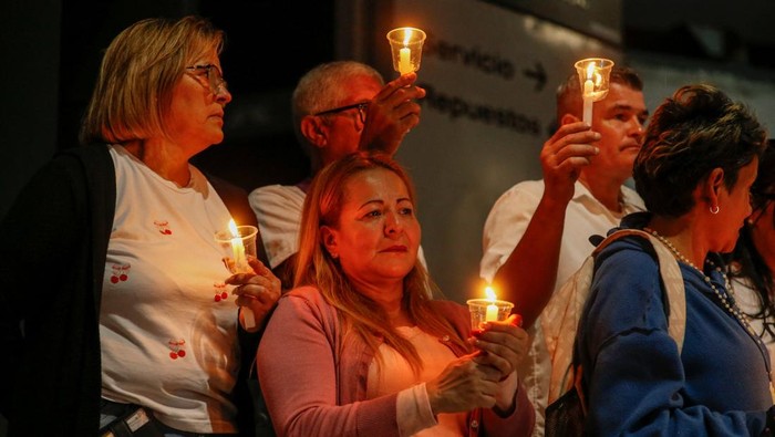 Malam di kawasan El Helicoide, pusat penahanan terkenal di ibu kota Venezuela, dipenuhi harapan dan kecemasan. Puluhan keluarga tahanan politik berkumpul di luar tembok beton fasilitas itu, menyalakan lilin dan berdoa sambil menanti kabar pembebasan kerabat mereka yang sudah lama ditahan. REUTERS/Leonardo Fernandez Viloria