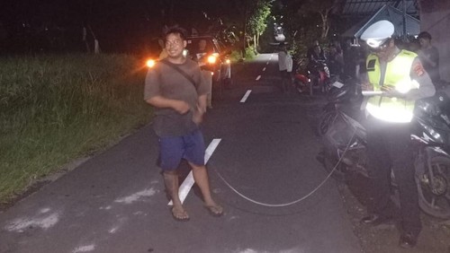 Polisi mengecek lokasi tabrakan dua pemotor yang menyebabkan satu pengendara tewas di Jalan Kubutambahan km 21, tepatnya di Banjar Dinas Pakisan, Kecamatan Kubutambahan, Buleleng, Sabtu (10/1/2026) malam. (Dok. Polres Buleleng)