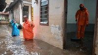 Petugas Penanganan Prasarana dan Sarana Umum (PPSU) dikerahkan untuk mengeluarkan air dari rumah-rumah terdampak dan membantu meringankan dampak banjir bagi warga. ANTARA FOTO/Sulthony Hasanuddin  
