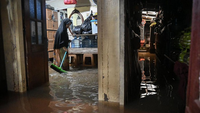 Warga membersihkan rumahnya yang terendam banjir di kawasan Jalan NIS, Cilandak Timur, Jakarta, Senin (12/1/2026). BPBD DKI Jakarta mencatat banjir setinggi 20-95 sentimeter melanda 10 rukun tetangga (RT) di Jakarta Selatan dan Jakarta Utara yang disebabkan curah hujan tinggi. ANTARA FOTO/Sulthony Hasanuddin/bar