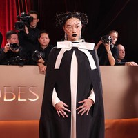 Audrey Nuna dari film ‘KPop Demon Hunters’  bersolek dengan gaya avant-garde dalam cape hitam-putih dengan pita besar rancangan Thom Browne. Look sarat statement ini terasa artistik, eksperimental, dan menegaskan identitas fashion-forward sang musisi. (Foto: Christina House/Los Angeles Times via Getty Images)