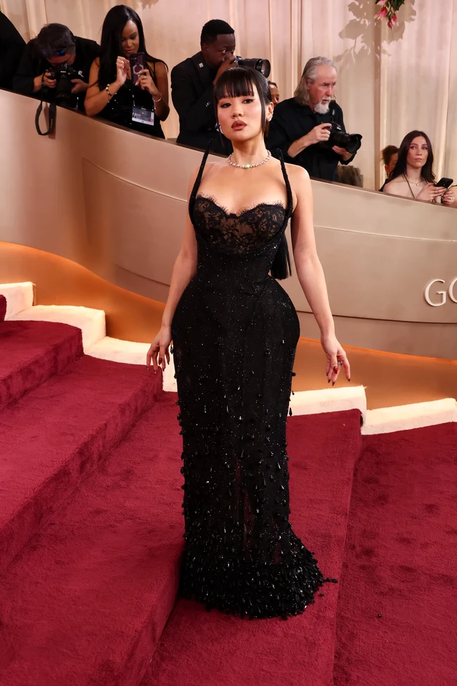 Tak ketinggalan, Rei Ami, pengisi suara Zoey di film KPop Demon Hunters bergaun renda hitam dengan detail manik-manik dan garis leher berbentuk hati. Ia menghadirkan sisi feminin dan chic di red carpet Golden Globe Awards 2026 dilengkapi kalung berlian. Foto: Getty Images