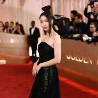 Penyanyi EJAE, yang populer sebagai pengisi soundtrack film animasi KPop Demon Hunters memilih gaya goth chic dengan gaun hitam tanpa tali beraksen renda dan detail rok menggelembung, serta sleek updo hairstyle. EJAE mewakili rekan-rekannya untuk menerima piala penghargaan “Best Original Song - Motion Picture” untuk lagu Golden. Foto: Getty Images