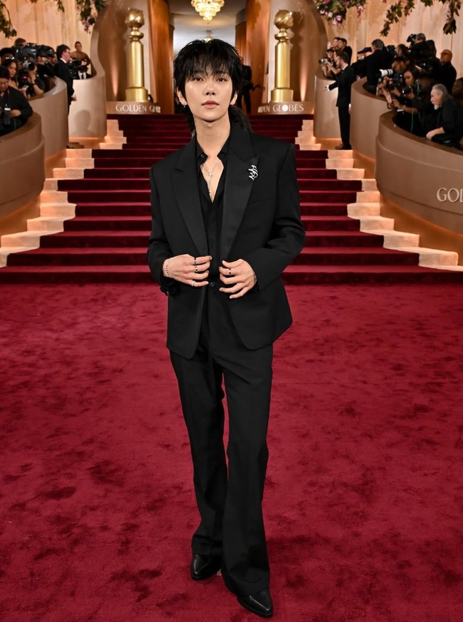 Seperti Lisa BLACKPINK, Joshua SEVENTEEN juga memulai penampilan debutnya di Golden Globe Awards 2026. Terlihat menawan memakai setelan jas hitam ramping dari Givenchy, dengan beberapa kancing yang dibiarkan terbuka. Koleksi perhiasan Chaumet mulai dari anting, kalung, cincin, dan bros menyempurnakan gayanya. Foto: Getty Images