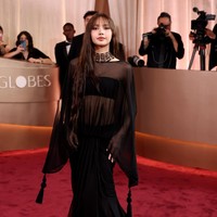 Lisa BLACKPINK mencatat sejarah sebagai idol KPop pertama yang ditunjuk menjadi presenter Golden Globe Awards 2026. Ia memancarkan keanggunannya saat tiba di red carpet, berbalut gaun hitam transparan rancangan Jacquemus, dipadukan dengan kalung choker bertingkat berhias batu berlian. Foto: Getty Images