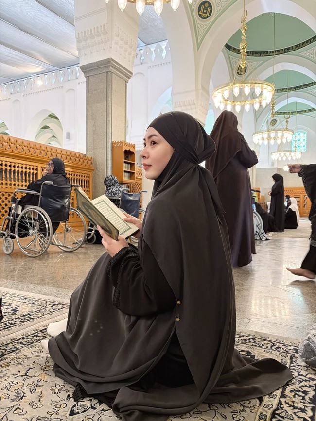 Saat berada di Masjid Quba, Ayana terlihat khusyuk membaca Al-Quran dengan mengenakan hijab syari dan abaya berwarna hitam. Foto: Dok. Instagram @xolovelyayana.