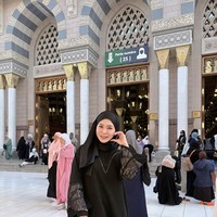 Berpose di depan pintu gerbang masjid Nabawi, Ayana menggunakan hijab pashmina hitam yang disampirkan salah satu sisinya ke bahu. Perpaduan antara hijab gelap dan gamis senada dengan detail renda di bagian bawah membuat penampilannya terlihat sopan dan simpel. Foto: Dok. Instagram @xolovelyayana.