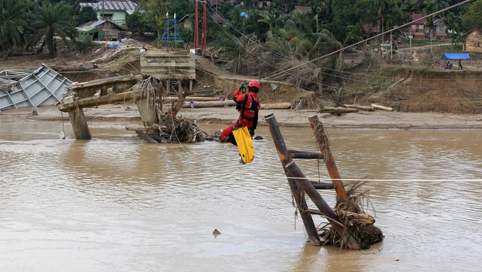 Relawan Vertical Rescue Indonesia membangun jembatan gantung melintasi sungai Tamiang di Desa Lubuk Sidup, Aceh Tamiang, Aceh, Senin (12/1/2026). Jembatan gantung sepanjang 240 meter yang dibangun Kemenhan, TNI dan Vertical Rescue Indonesia untuk menghubungkan kembali kecamatan Sekarak dengan Bandar Pusaka yang terputus karena rusaknya jembatan permanen akibat bencana banjir bandang dan luapan sungai Tamiang akhir November 2025. ANTARA FOTO/Irwansyah Putra/nz.