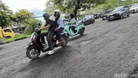 Para pengendara berhati-hati saat melintas di Jalan Perintis Kemerdekaan yang rusak karena berisiko terhadap keselamatan