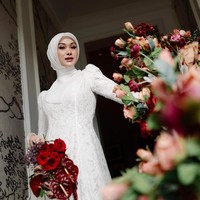 Detail gaya hijab Indah terlihat semakin jelas pada foto jarak dekat, di mana material hijab segi empat dipasang dengan teknik lilitan yang presisi oleh @hijabdo.byputri. Penggunaan dalaman hijab yang pas membuat tatanan kerudungnya tetap tegak di dahi dan membingkai wajahnya dengan sempurna. Foto: Dok. Instagram @indahnadapuspita