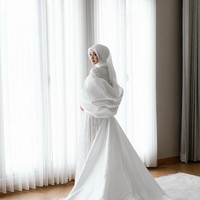 Menambah kesan mewah, Indah mengenakan gaun putih panjang dari brand miliknya @nadapuspita.official, yang dipadukan dengan hijab senada dan tambahan cape yang menjuntai anggun rancangan @yantiadeni. Foto: Dok. Instagram @indahnadapuspita.