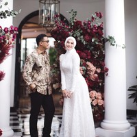 Wanita kelahiran 18 Juni 1993 ini memilih dekorasi floral yang mewah. Suasana lamaran semakin elegan dengan latar belakang kain merah marun yang dramatis serta hiasan bunga mawar merah dan peach yang tersusun cantik di antara pilar putih klasik oleh @memulaicerita.  Foto: Dok. Instagram @indahnadapuspita.