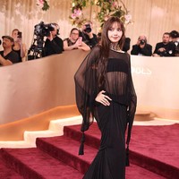 Lisa Blackpink memilih busana hitam transparan dengan cape panjang dari Jacquemus. Siluet sleek dan permainan layering memberi kesan modern, edgy, dengan detail tassel yang sekaligus sangat high-fashion, mempertegas statusnya sebagai ikon K-pop sejati. (Foto: Jason Armond/Los Angeles Times via Getty Images)