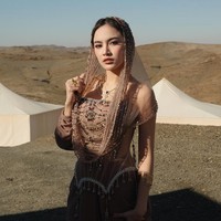 Mahalini tampil kian memukau dengan tudung atau hood transparan bernuansa keemasan. Hooded tersebut dihiasi rangkaian manik-manik dan detail berkilau yang menjuntai lembut mengikuti garis wajah hingga bahu. Foto: Instagram/@mahaliniraharja