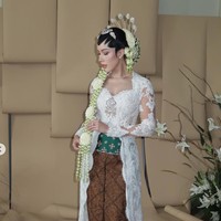 Patricia mengenakan kebaya rancangan desainer Didiet Maulana. Kebaya putih berbahan lace transparan itu dipercantik dengan detail bordir halus. Potongannya fitted mengikuti siluet tubuh, dilengkapi ekor kebaya panjang yang memberi kesan sakral dan mewah khas akad nikah adat Jawa. Foto: Instagram/@rhay_david